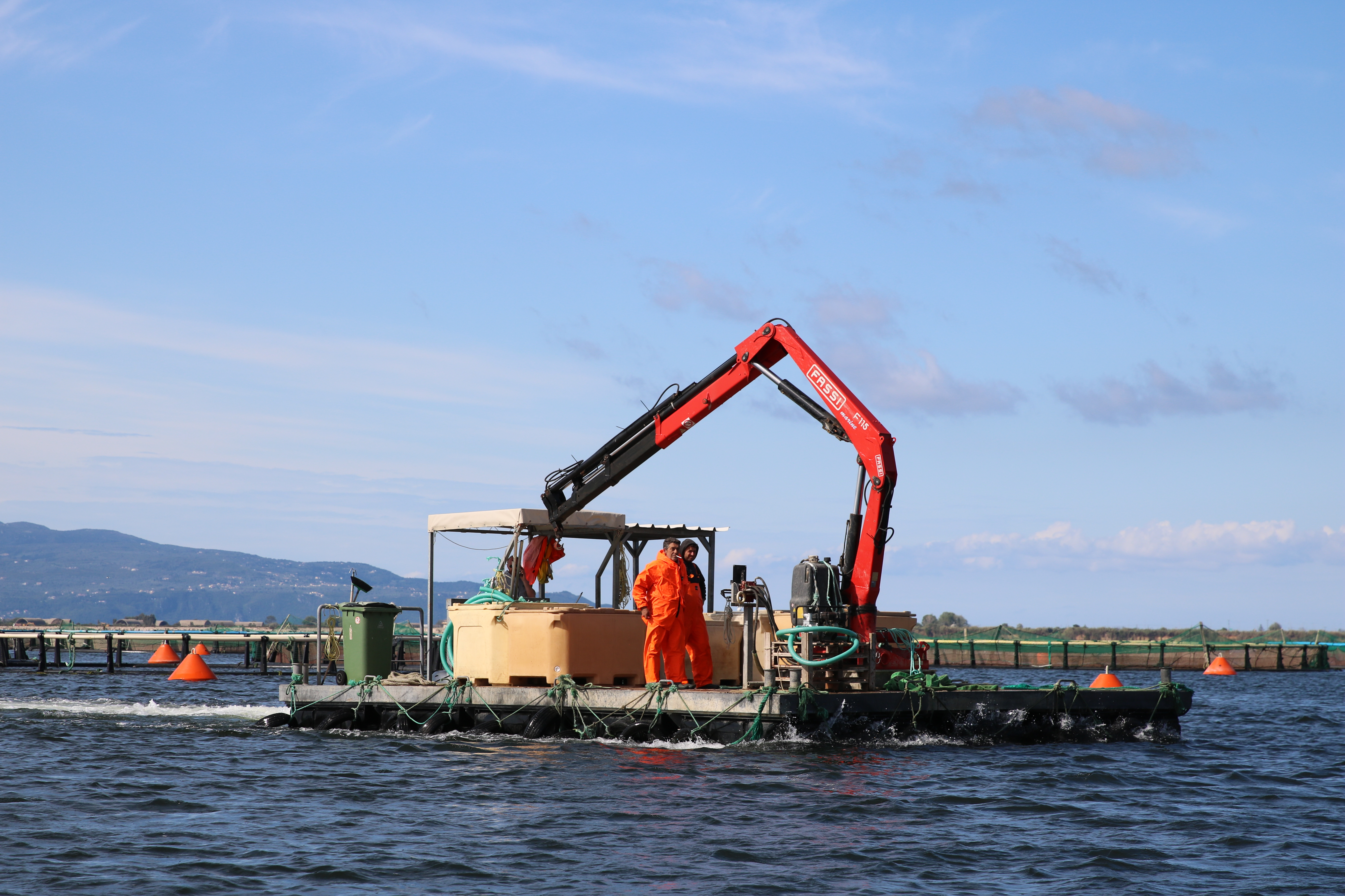 Workers seen operating a feed barge. Critics argue Greek aquaculture hasn’t created any new jobs in the last 20 years.