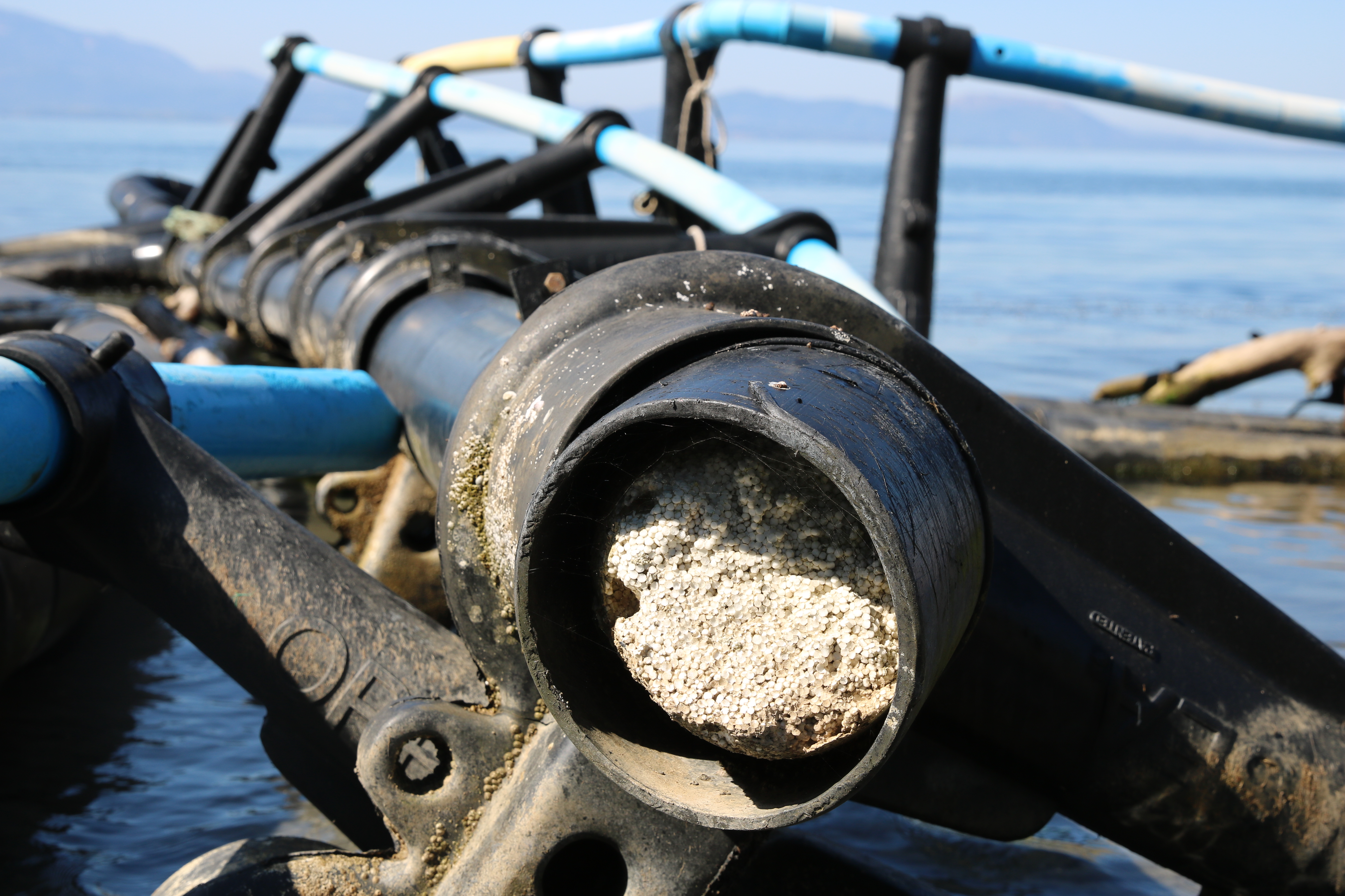 Polystyrene pellets exposed by cracked aquaculture infrastructure. Such pellets litter beaches nationwide amounting to one third of Greek coastal trash.