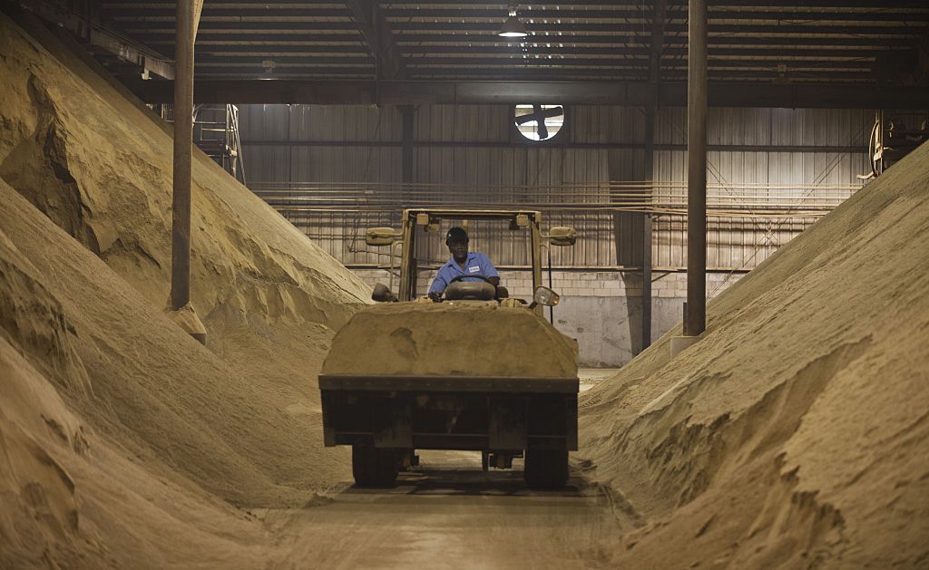 A worker drove a tractor past mounds of dried and crushed menhaden fish at the Omega Protein processing plant in Reedville, Virginia, on June 23, 2015.