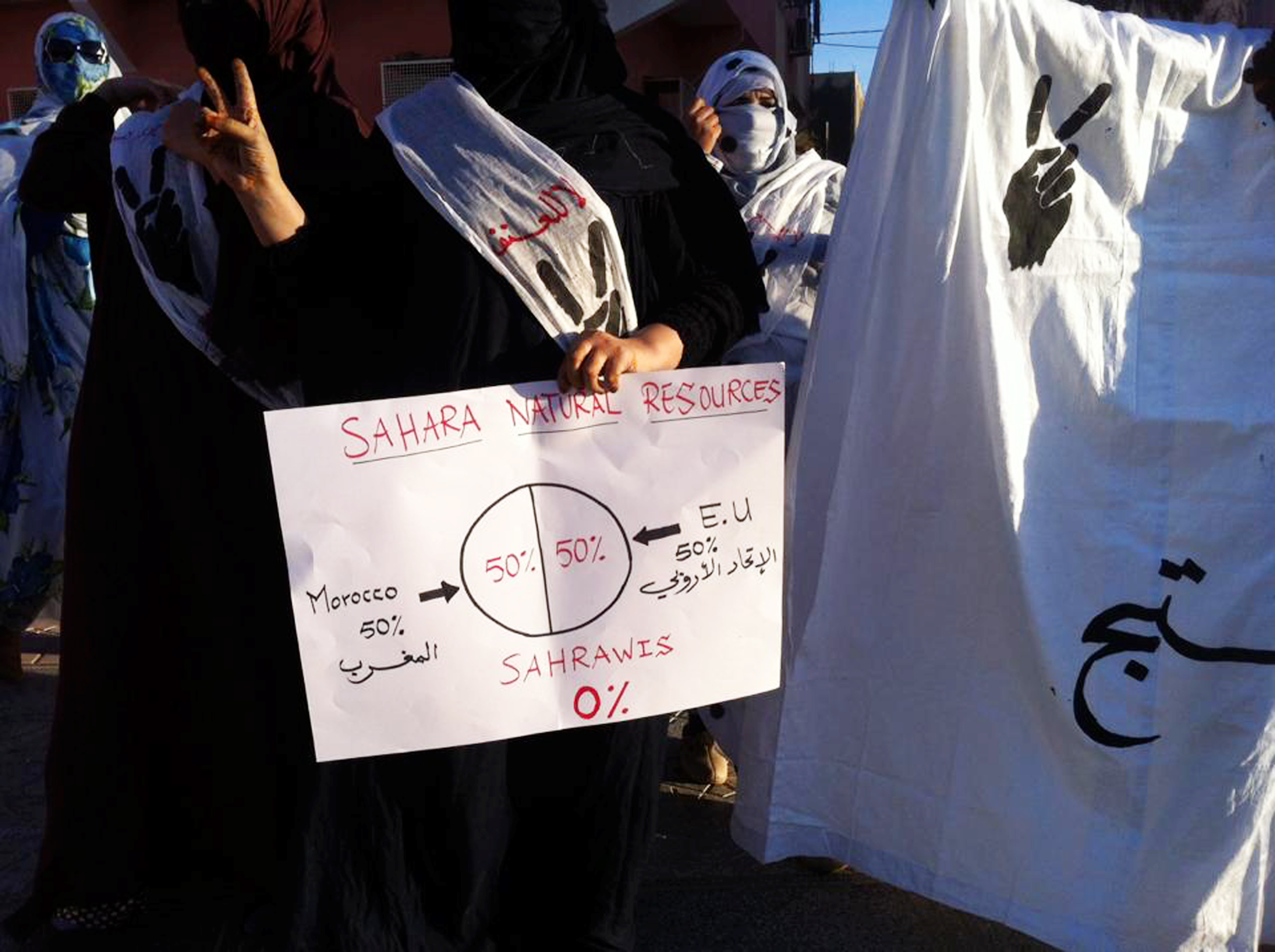 A Sahrawi demonstrator held up a sign criticizing resource-sharing between Morocco and the European Union in Western Sahara. Between 2018 and 2021, the EU paid Morocco over $230 million for fishing access under a partnership agreement. Sahrawi representatives argued that the people of Western Sahara did not consent to the arrangement or receive its proceeds.
